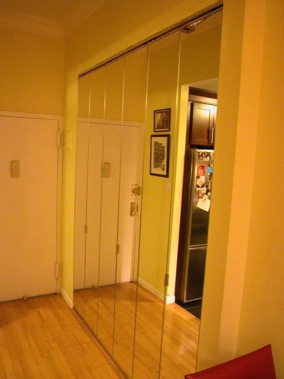 Mirrored bi-fold closet doors installed in a residential hallway.